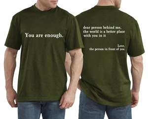 Détail du t-shirt vert olive montrant le slogan 'You are enough' et l'imprimé au dos