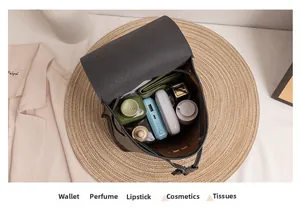 Internal storage view of the bucket backpack holding a wallet, perfume, and cosmetics