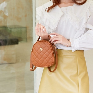 Sac à dos matelassé couleur chameau avec logo trèfle doré et poignée supérieure chic
