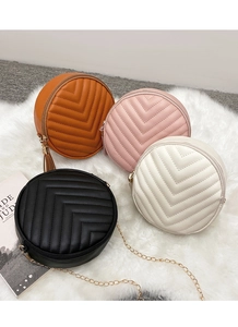 Detailed display of four round quilted crossbody bags with gold chains and tassels