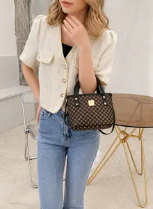 Detail of printed bucket bag featuring coffee geometric pattern and gold hardware