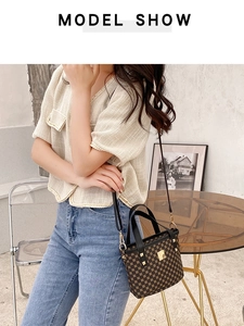 Model showing the brown geometric printed bucket bag with gold rivets and strap