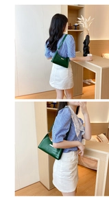 Detail of dark green crocodile texture shoulder bag with elegant gold metal hardware