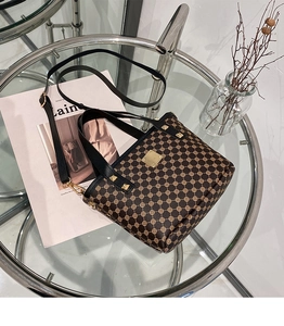 Detail view of brown bucket bag with geometric patterns and golden metal studs