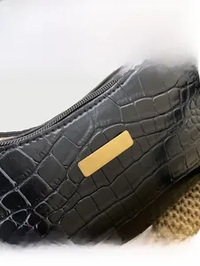 Detail of black crocodile texture bag with premium gold rectangular metal plate