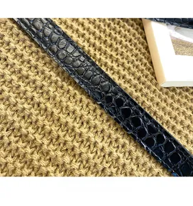 Detail of black faux crocodile leather shoulder strap with durable stitching and glossy finish