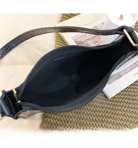 Spacious interior of a black crocodile-pattern shoulder bag with metallic zipper detail