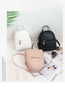 Three mini quilted backpacks in white black and pink with gold zippers and metal charms