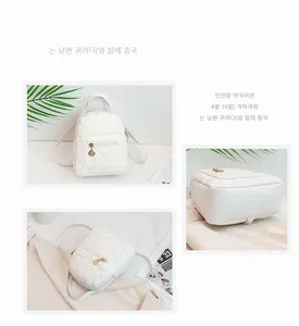 Close-up of white quilted mini backpack with golden zipper and rhombus stitching