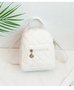 Detailed close-up of a white quilted mini backpack featuring a circular metal zipper puller