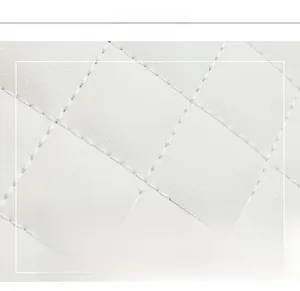 Close-up of white quilted faux leather texture with detailed diamond embroidery stitching