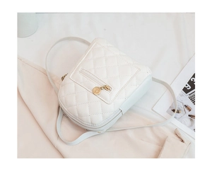 Detail of white quilted backpack with diamond stitching and round gold zipper pendant