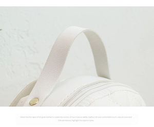 Close-up of white full-grain leather backpack featuring quilted stitching and metal hardware