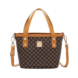 Retro brown bucket bag with gold clover print and rivet studs on white background