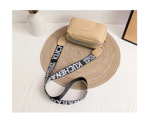 Dettaglio borsa a tracolla beige con cinturino jacquard fantasia e fibbia dorata