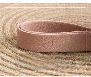 Detailed macro view of a pink textured leather shoulder strap with fine stitching details