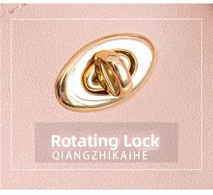 Detail of pink lychee leather handbag featuring a golden oval twist lock closure mechanism