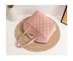 Close-up of pink quilted leather handbag featuring a golden turn-lock and rivet details