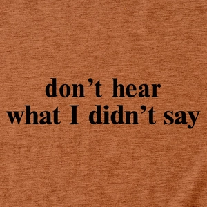 Dettaglio macro della stampa 'don't hear what I didn't say' su tessuto in maglia caramello