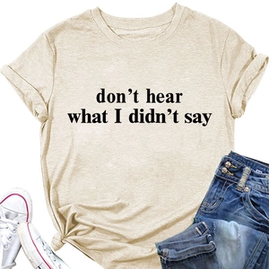 Dettaglio della t-shirt color albicocca con scritte nere e orlo annodato stile casual