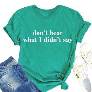 Piatto di una maglietta verde con stampa di slogan bianchi e jeans in denim strappati