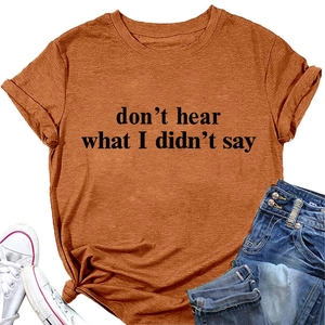 Dettaglio di una t-shirt rosso ruggine con trama in cotone e scritte grafiche stampate