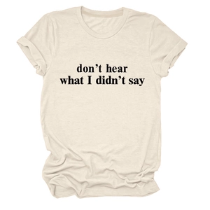 Dettaglio delle maniche risvoltate e tipografia nera sulla t-shirt in cotone beige