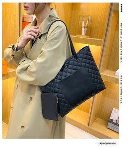 Black quilted tote bag featuring a matching detachable zipper pouch and front pocket detail