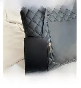 Close-up of black quilted tote bag texture with a matching square zipper pouch detail