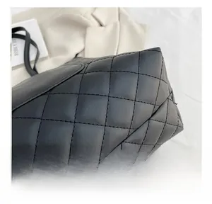 Detailed close-up of quilted diamond stitching on black leather handbag with shoulder strap