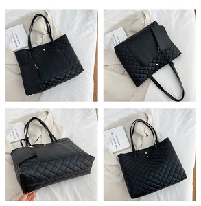 Detail view of black quilted tote bag set with matching coin purse and gold hardware