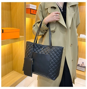 Close-up of black quilted tote bag set with matching pouch and elegant metallic buckle detail