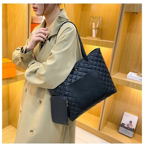 Close-up of black quilted tote bag with matching pouch and stylish shoulder straps