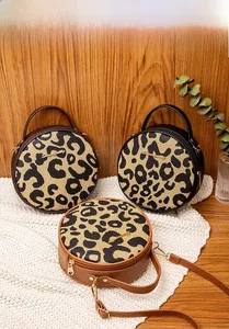 Dettaglio di tre borse rotonde a tracolla leopardate con finiture in pelle PU e logo