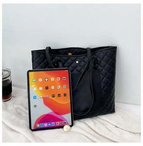 Top view of large black quilted tote bag with chain strap and gold magnetic closure