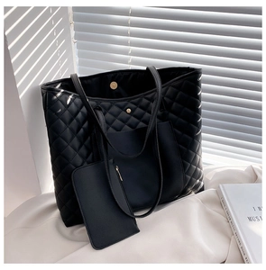 Close-up of black quilted tote bag with matching zippered pouch and magnetic closure