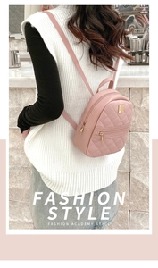 Detail of pink quilted leather mini backpack with gold hardware worn by a model