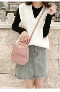 Pink quilted mini bag shown as a crossbody with gold metal hardware and zipper details