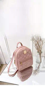 Detail of pink quilted mini backpack showing adjustable straps and gold zippers