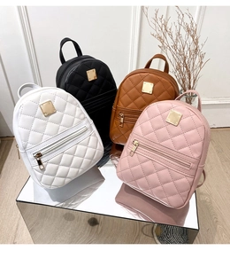 Detailed view of mini quilted backpacks with gold hardware and square logo plate
