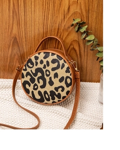 Dettaglio della borsa rotonda leopardata con finiture in pelle marrone e metallo oro