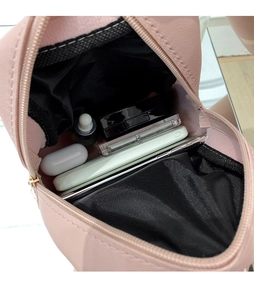 Detail view of pink quilted mini backpack interior showing storage for phone and makeup