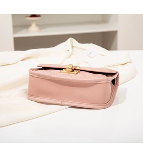 Gros plan du sac matelassé rose montrant le fermoir doré et les détails de couture