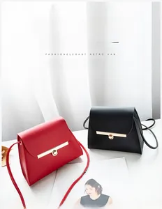 Detail of minimalist red and black leather crossbody bags with gold metal clasps