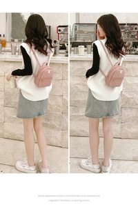 Detail of pink quilted PU leather mini backpack with gold hardware in casual cafe setting