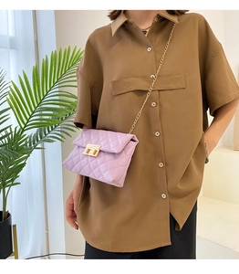 Detail of lavender quilted shoulder bag with gold metal chain and turn-lock closure