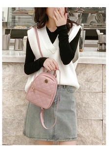 Close-up of pink quilted mini backpack with gold hardware and zipper detail