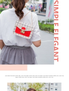 Detail view of stylish plaid crossbody bag with red leather trim and gold chain strap