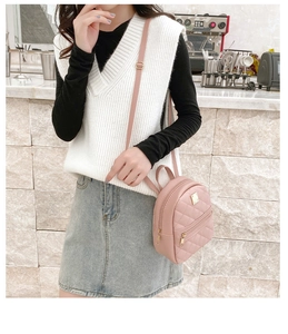 Pink quilted PU leather mini backpack with gold logo plate worn as a crossbody bag