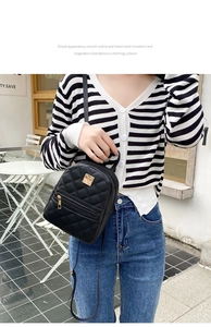 Close-up of a black quilted mini backpack with golden metal accents and adjustable straps